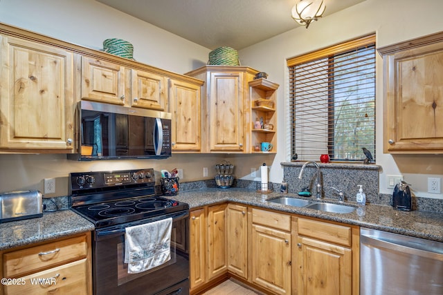 kitchen with dark stone counters, stainless steel appliances, and a sink