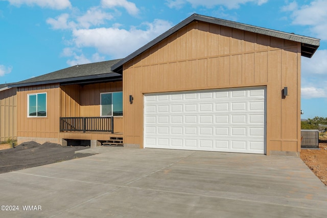 view of front of property with driveway, a shingled roof, and a garage