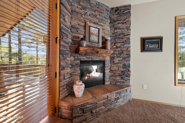 unfurnished living room with carpet floors, a fireplace, and baseboards