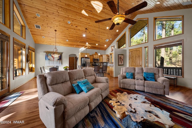 living area featuring arched walkways, visible vents, wood finished floors, high vaulted ceiling, and wooden ceiling