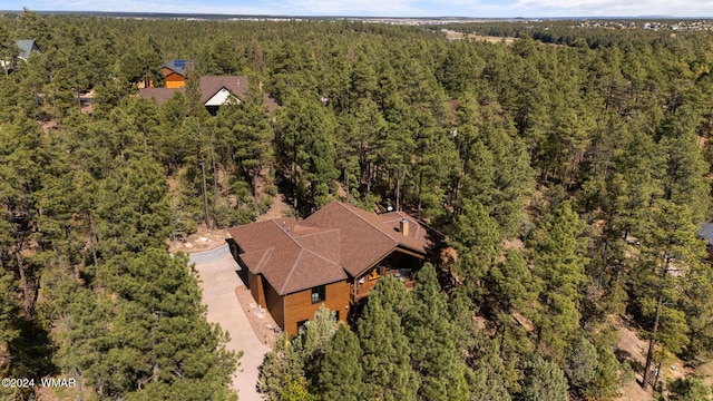 birds eye view of property featuring a forest view