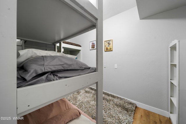 bedroom with baseboards and wood finished floors