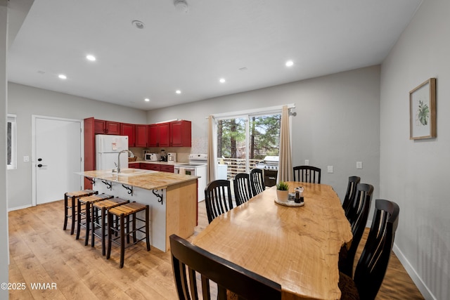 dining space with recessed lighting, baseboards, and light wood finished floors