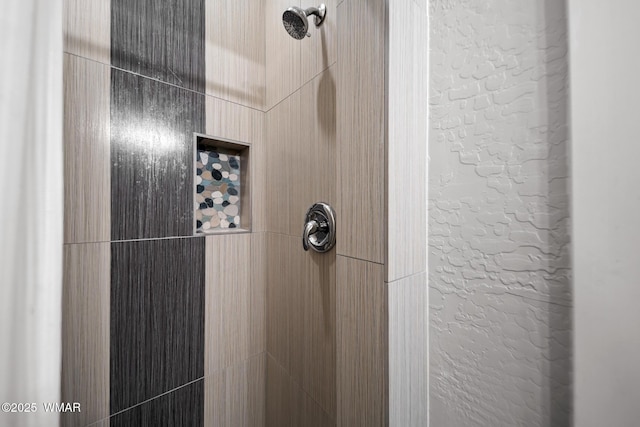 details featuring a textured wall and a tile shower