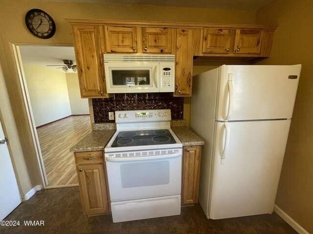 kitchen with baseboards, white appliances, brown cabinetry, and tasteful backsplash