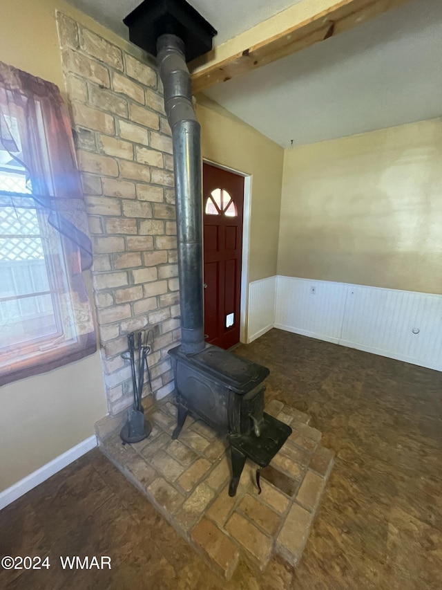 interior space featuring a wood stove and a wainscoted wall