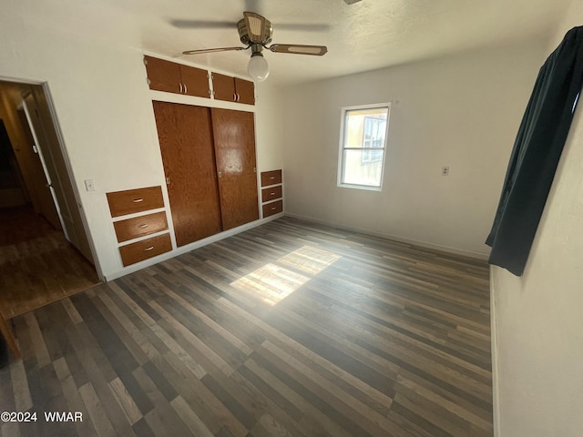 unfurnished bedroom with dark wood-type flooring, a closet, and ceiling fan