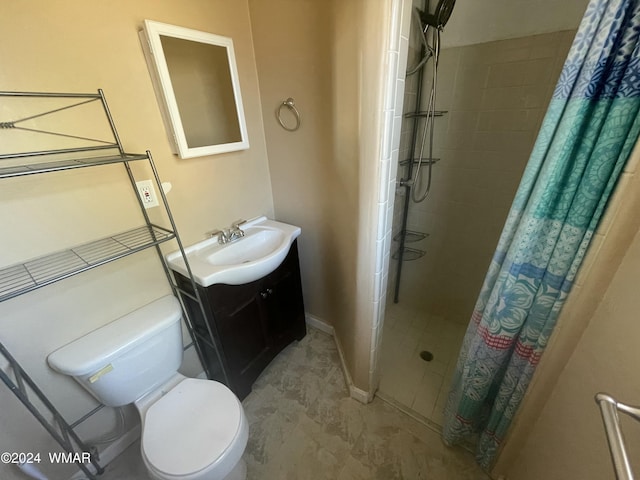 full bathroom with toilet, a shower stall, baseboards, and vanity