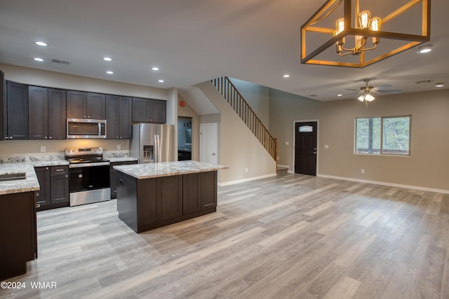 2362 Aspen Run, Pinetop, AZ 85935 - kitchen with light stone counters, pendant lighting, appliances with stainless steel finishes, open floor plan, and a kitchen island