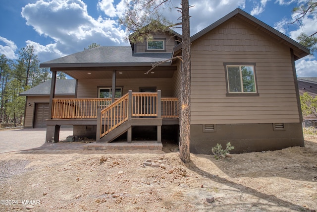 rear view of house with a garage, roof with shingles, crawl space, and driveway