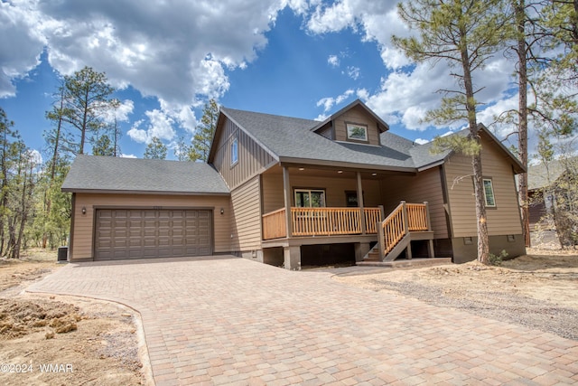 rustic home featuring a shingled roof, stairway, an attached garage, crawl space, and decorative driveway