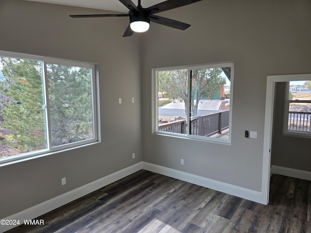 empty room with a ceiling fan, baseboards, and dark wood-type flooring