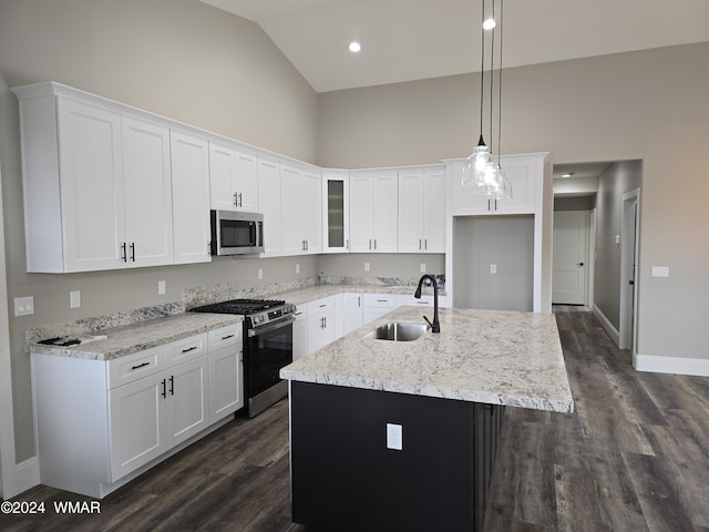 kitchen with stainless steel appliances, an island with sink, and white cabinetry