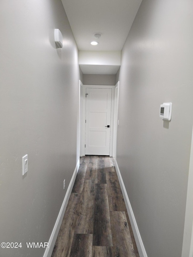 corridor with baseboards and wood finished floors