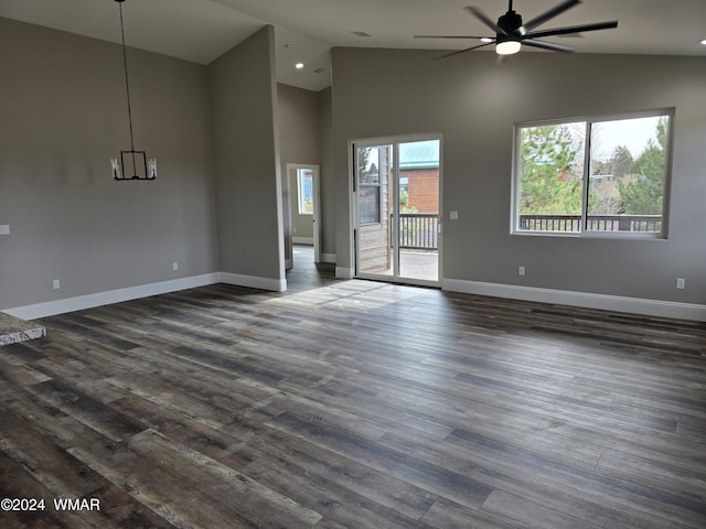 unfurnished living room featuring dark wood-style floors, ceiling fan, and baseboards