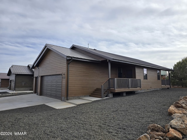 view of front of property featuring a garage, metal roof, and concrete driveway