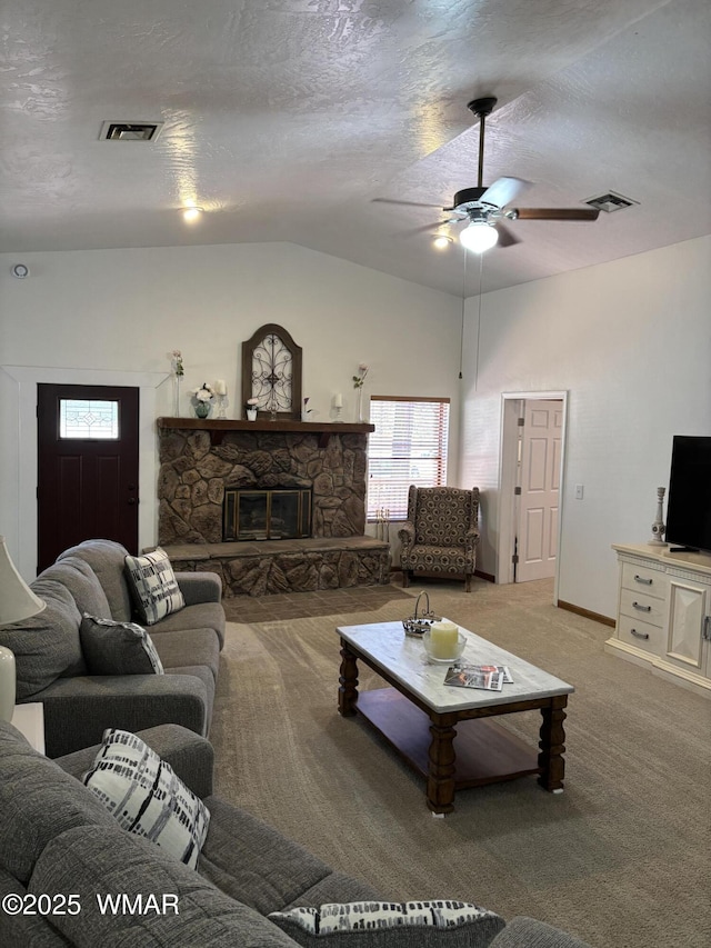 carpeted living room featuring a stone fireplace, a textured ceiling, visible vents, and vaulted ceiling