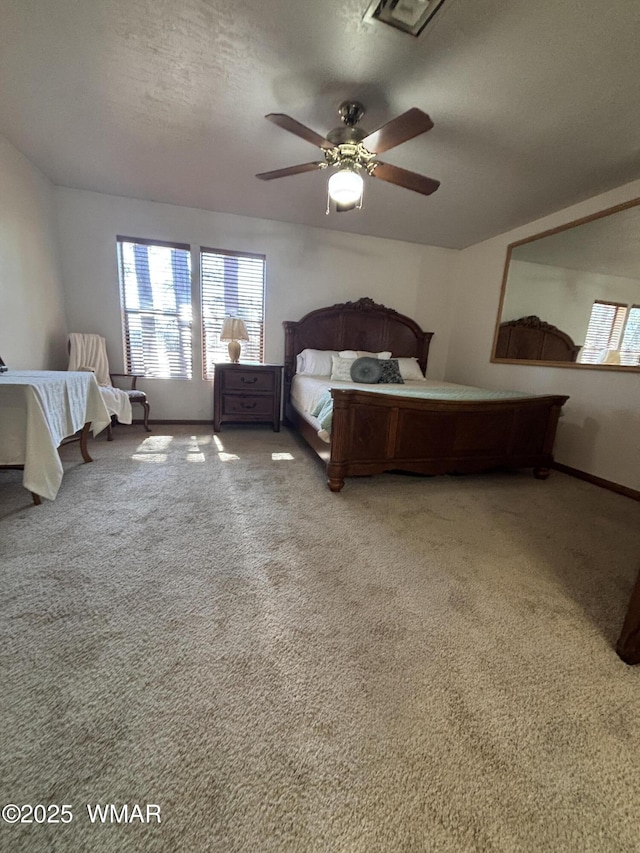 bedroom featuring a ceiling fan, carpet, baseboards, and a textured ceiling