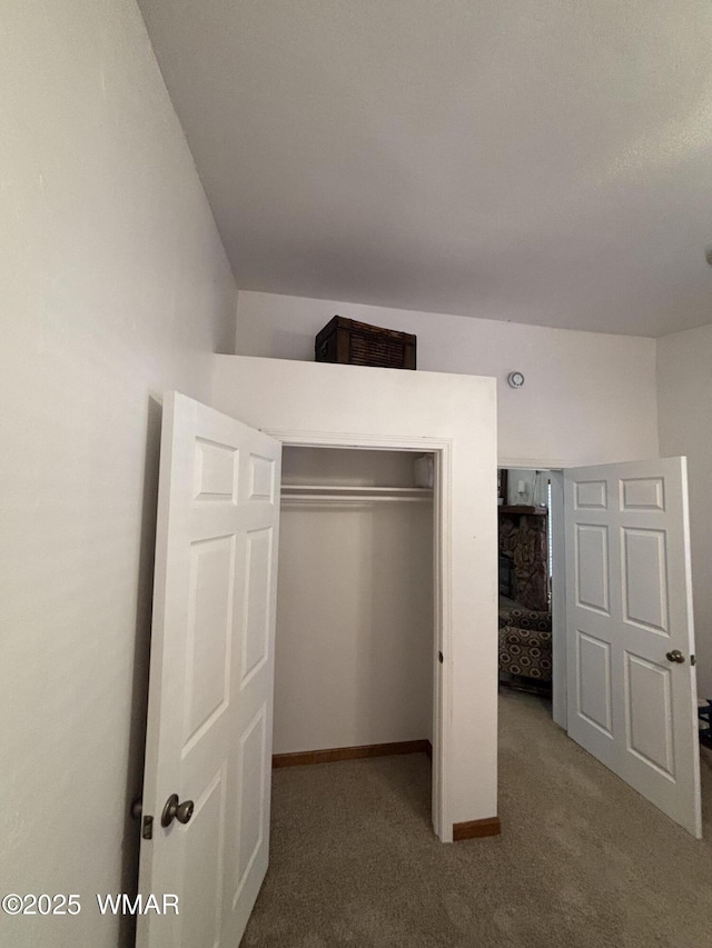 unfurnished bedroom featuring a closet, baseboards, and carpet flooring