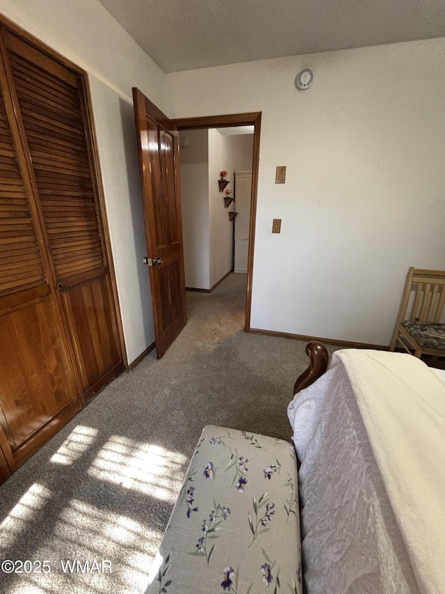 bedroom with a closet, baseboards, and carpet