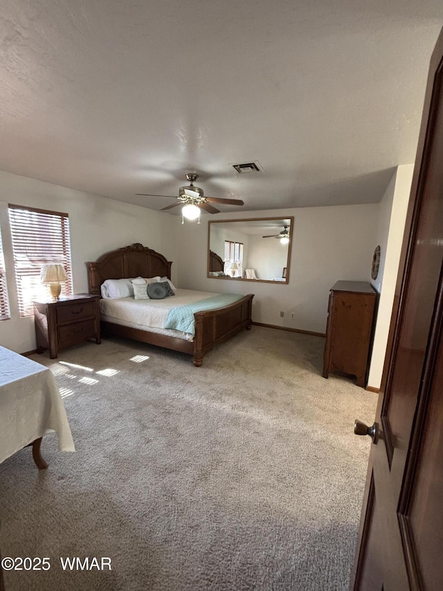 bedroom featuring ceiling fan, baseboards, visible vents, and light carpet