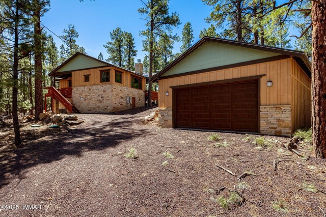 3 County Road 1058, Greer, AZ 85927 - view of side of home featuring stone siding, an outdoor structure, stairs, and a detached garage