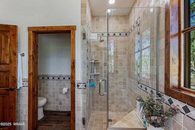 3 County Road 1058, Greer, AZ 85927 - bathroom featuring tile walls, toilet, a shower stall, wainscoting, and wood finished floors