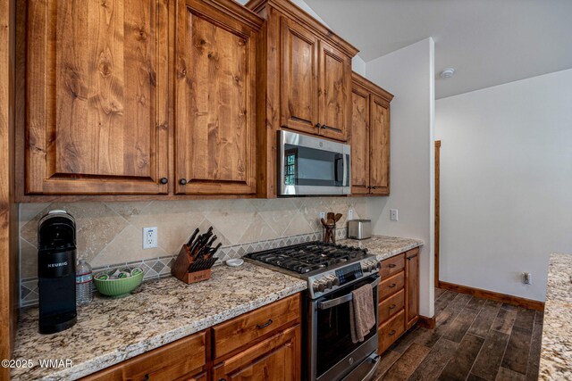 3 County Road 1058, Greer, AZ 85927 - kitchen featuring stainless steel appliances, decorative backsplash, brown cabinets, and dark wood-style floors