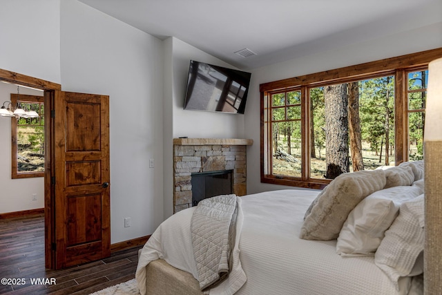3 County Road 1058, Greer, AZ 85927 - bedroom with wood finished floors, baseboards, a fireplace, and a chandelier