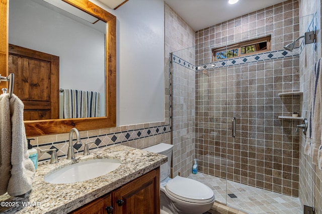 3 County Road 1058, Greer, AZ 85927 - bathroom with toilet, vanity, tile walls, a stall shower, and wainscoting