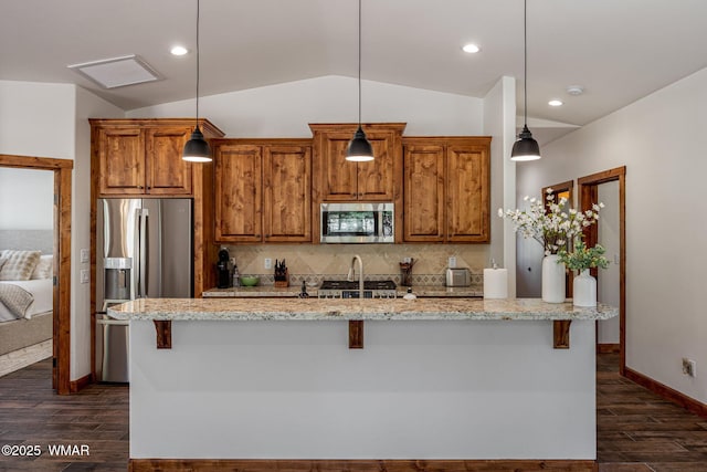 3 County Road 1058, Greer, AZ 85927 - kitchen with appliances with stainless steel finishes, vaulted ceiling, dark wood-type flooring, brown cabinets, and tasteful backsplash
