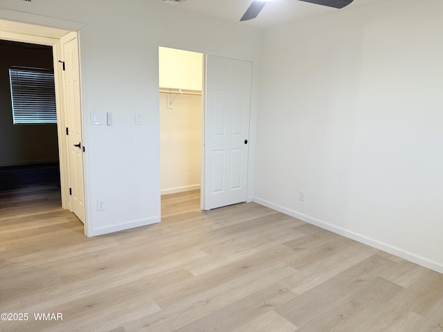412 W 8th St S, Snowflake, AZ 85937 - unfurnished bedroom featuring a walk in closet, baseboards, light wood-style flooring, a closet, and a ceiling fan