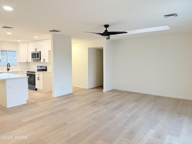 412 W 8th St S, Snowflake, AZ 85937 - kitchen featuring stainless steel appliances, open floor plan, light wood-type flooring, light countertops, and ceiling fan
