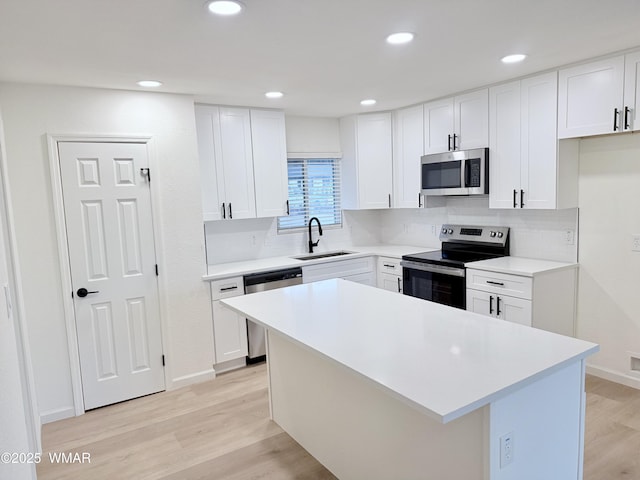 412 W 8th St S, Snowflake, AZ 85937 - kitchen featuring stainless steel appliances, a sink, light wood-style floors, white cabinets, and decorative backsplash