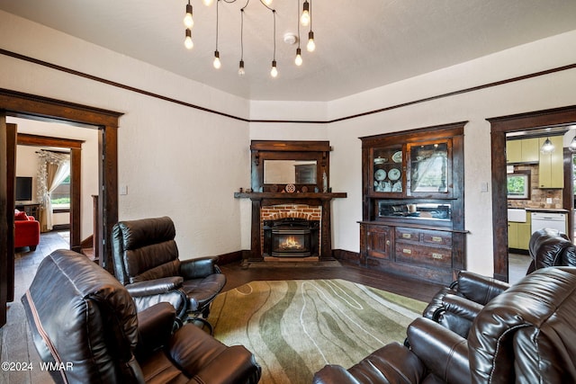 living area with a fireplace, baseboards, and wood finished floors