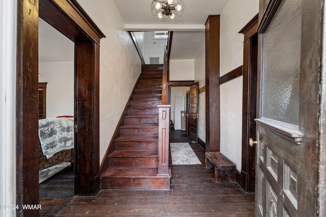 stairway featuring a chandelier, wood finished floors, and visible vents