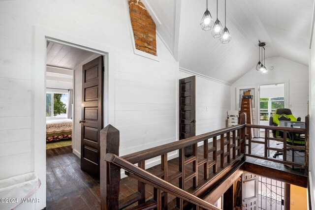 hall featuring dark wood-type flooring, lofted ceiling, and an upstairs landing