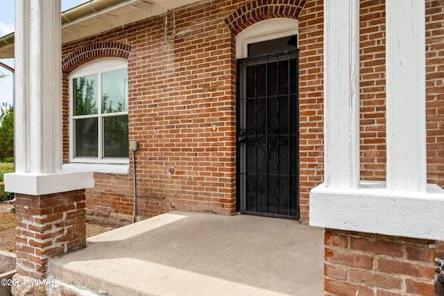 view of exterior entry with brick siding