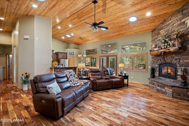 living room featuring wood finished floors, high vaulted ceiling, a stone fireplace, and wooden ceiling