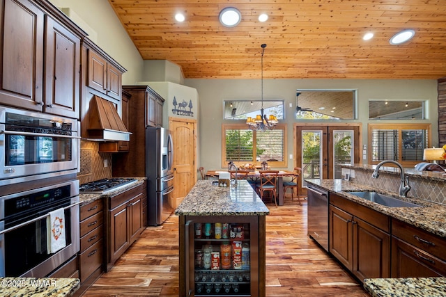 kitchen featuring custom exhaust hood, a sink, wine cooler, appliances with stainless steel finishes, and wooden ceiling