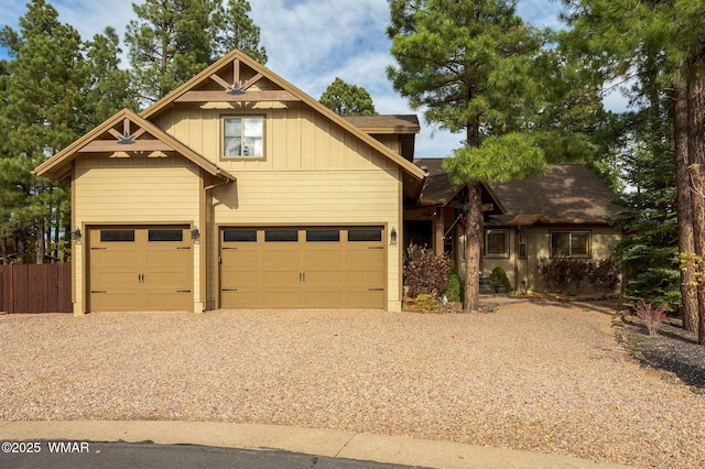 craftsman inspired home featuring a garage, fence, board and batten siding, and driveway