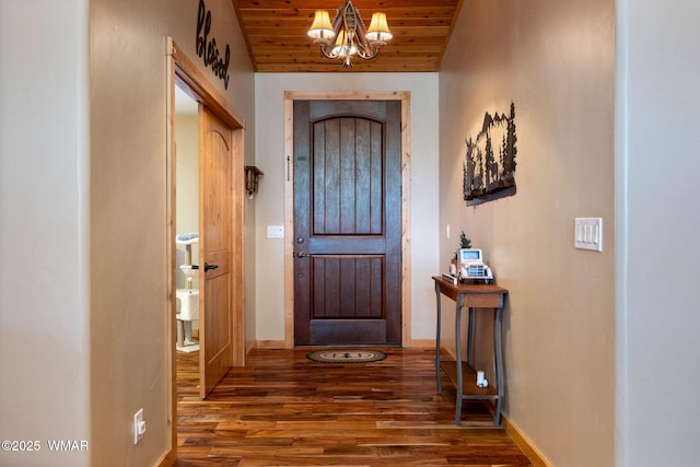 doorway to outside featuring baseboards, vaulted ceiling, wooden ceiling, an inviting chandelier, and wood finished floors