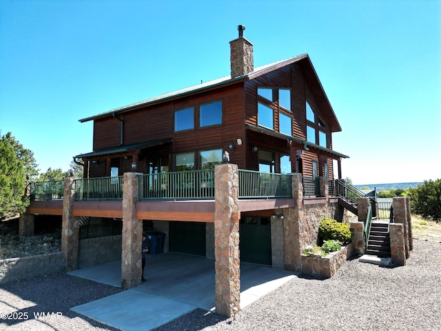 822 E 1st Ln, Eagar, AZ 85925 - rear view of house with driveway, a garage, stairway, a chimney, and stone siding