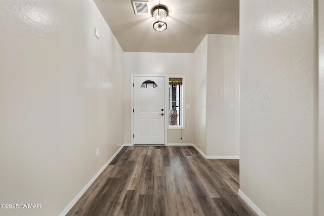 entrance foyer with dark wood-style flooring and baseboards