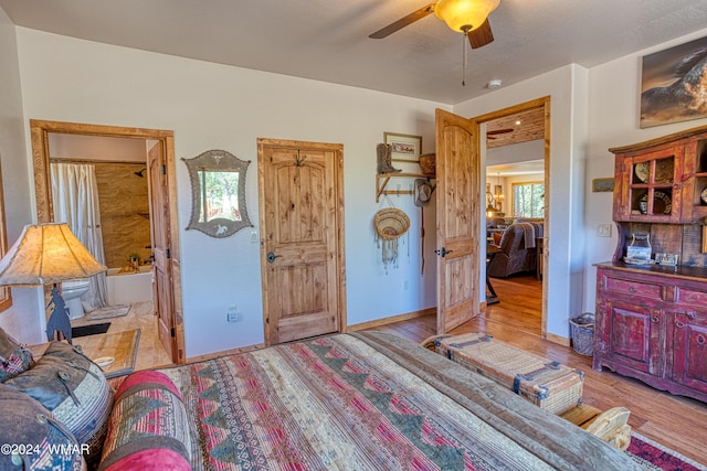 bedroom with ceiling fan, light wood-style flooring, and baseboards