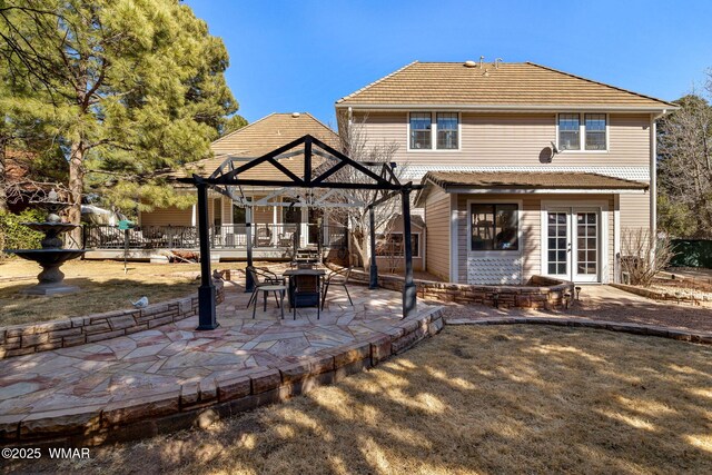 back of house featuring a tile roof, french doors, a patio area, and a pergola