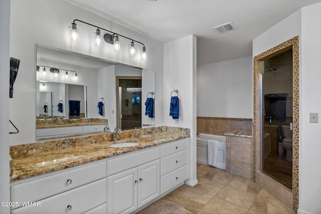 bathroom with a garden tub, toilet, vanity, visible vents, and a shower stall