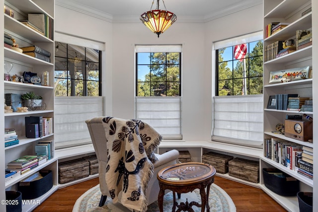 sitting room featuring ornamental molding and wood finished floors