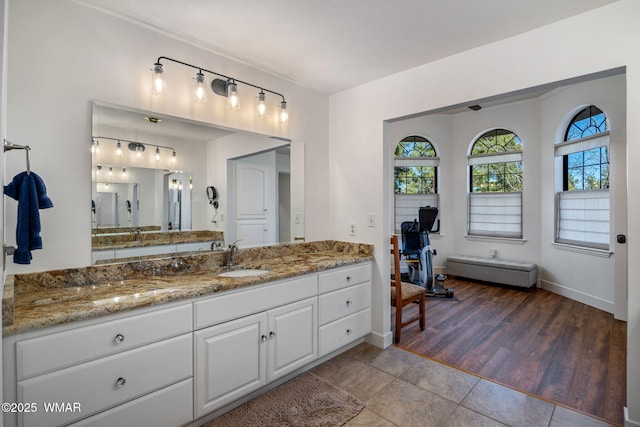 full bath featuring baseboards, wood finished floors, and vanity