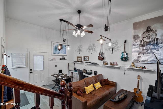 living area with ornamental molding and ceiling fan